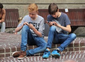 友達と一緒にいても会話ではなくスマートフォンを見ている子供たちの写真